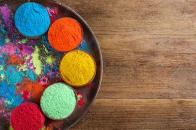 Colorful powder dyes on wooden background, top view with space for text. Holi festival