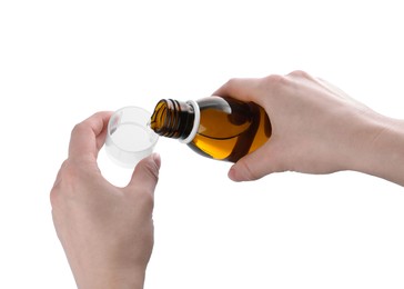 Photo of Woman pouring syrup into measuring cup from bottle isolated on white, closeup. Cough and cold medicine