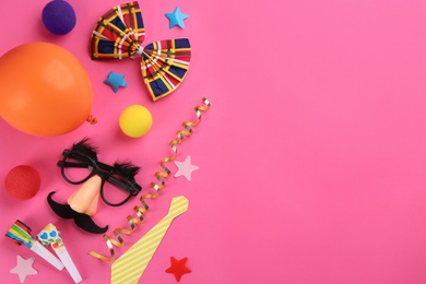 Flat lay composition with clown's accessories on pink background. Space for text