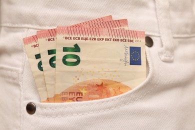 Euro banknotes in pocket of white jeans, closeup. Spending money