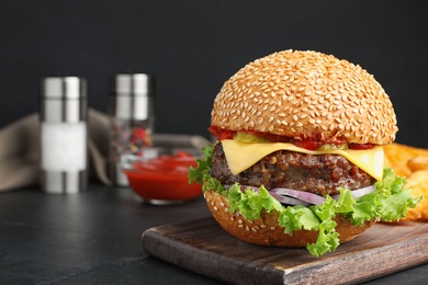 Delicious burger with meat cutlet on black table. Space for text