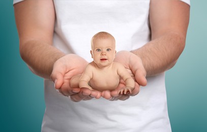 Surrogacy concept. Man holding cute little baby on color background, closeup