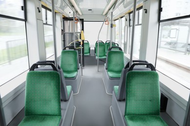Public transport interior with comfortable green seats and handgrip handles
