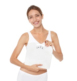 Photo of Happy slim woman satisfied with her diet results holding bathroom scales on white background