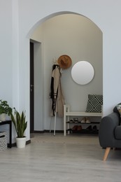 Photo of Hallway interior with clothes rack and round mirror