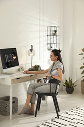 Young woman working at table in light room. Home office