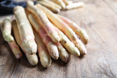 Pile of fresh white asparagus on wooden table, closeup