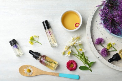 Flat lay composition with bottles of essential oils on light background