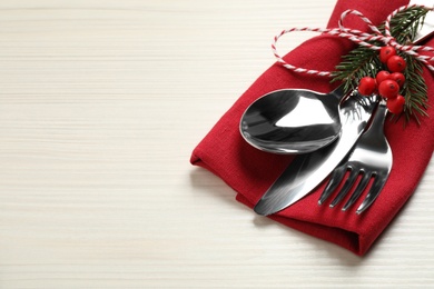 Cutlery set and festive decor on white wooden table, closeup with space for text. Christmas celebration