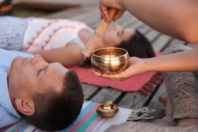 Couple at healing session with singing bowl outdoors