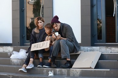 Poor homeless family begging and asking for help on city street