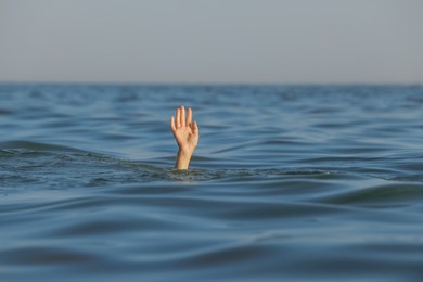 Photo of Drowning woman reaching for help in sea