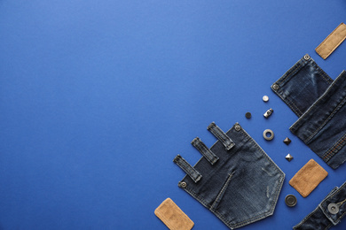 Photo of Flat lay composition with garment accessories and cutting details for jeans on blue background. Space for text