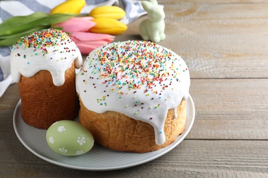 Easter cakes and color egg on wooden table, space for text
