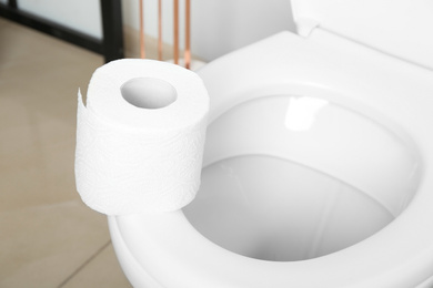 New paper roll on toilet seat in bathroom