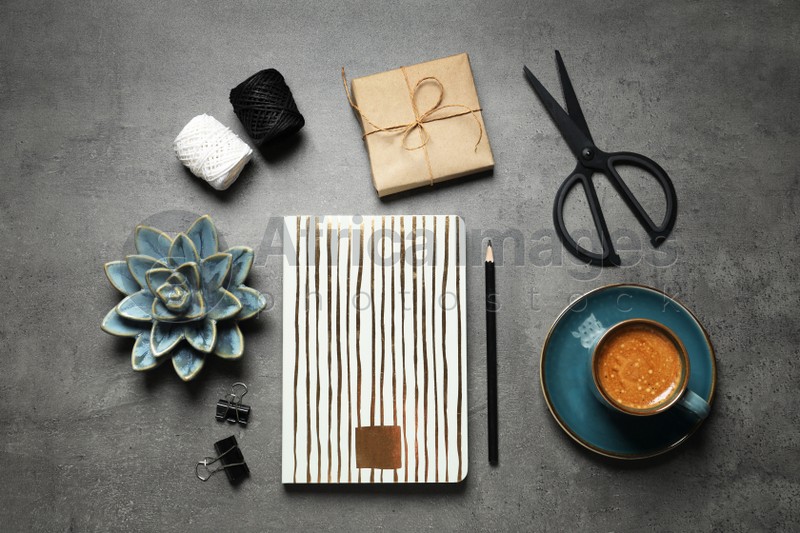 Flat lay composition with scissors, notebook and coffee on grey table