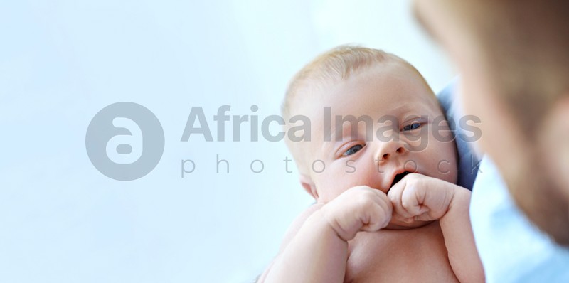Father holding his cute newborn baby at home, closeup view with space for text. Banner design