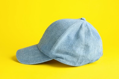 Stylish light blue denim baseball cap on yellow background