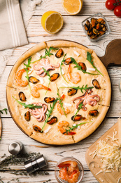 Delicious seafood pizza on white wooden table, flat lay. Food photography  