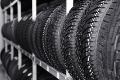 Car tires on rack in auto store, closeup