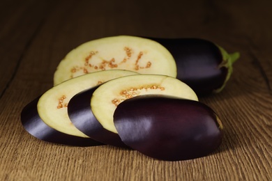 Cut purple eggplant on wooden table, closeup