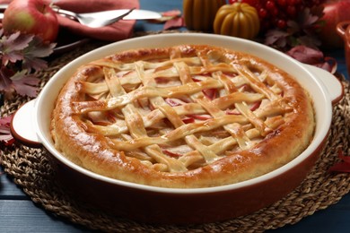 Delicious homemade apple pie and autumn decor on blue wooden table. Thanksgiving Day celebration