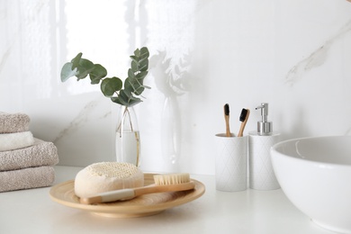 Photo of Fresh eucalyptus branches and bathroom items on countertop