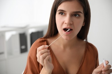 Woman taking sample for DNA test indoors