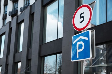 Photo of Traffic signs Parking and Speed Limit near modern building