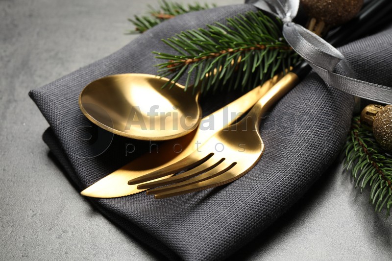 Cutlery set and Christmas decor on grey table, closeup