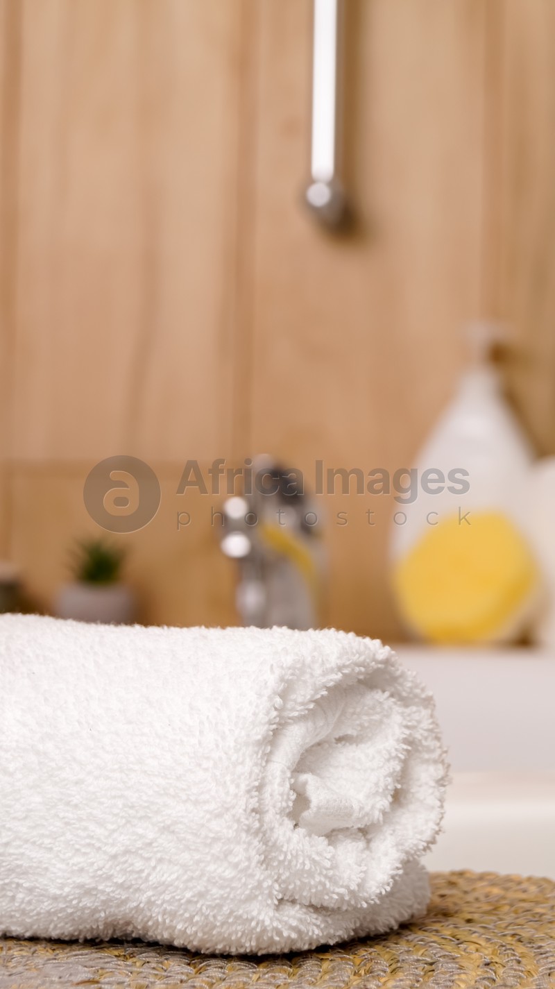 Rolled bath towel on table in bathroom