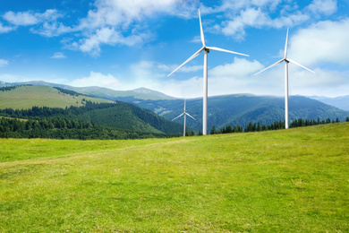 Alternative energy source. Wind turbines in mountains under blue sky