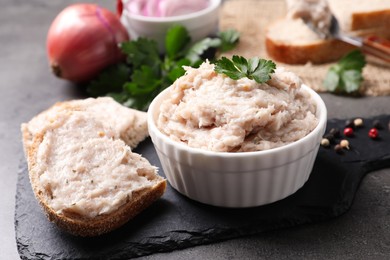 Photo of Delicious lard spread in bowl and sandwich on grey table