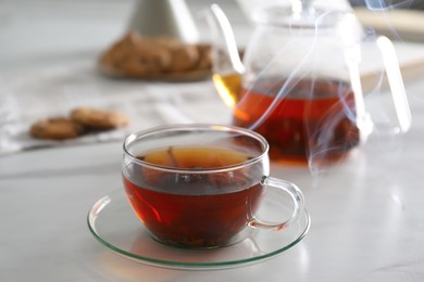 Photo of Glass cup of hot tea served for breakfast on white table