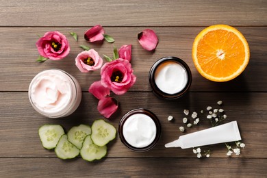 Photo of Flat lay composition with jars and tube of face cream on wooden table