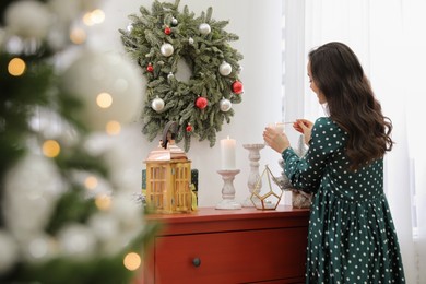 Woman lighting up candles at home. Christmas time