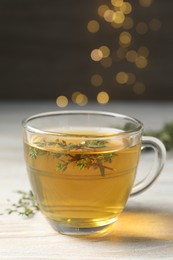 Photo of Cup of fresh thyme tea on wooden table