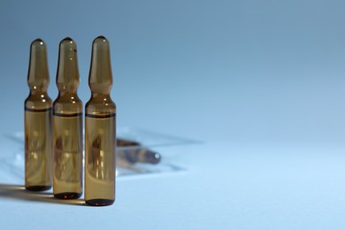 Brown pharmaceutical ampoules with medication on light background. Space for text