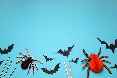 Flat lay composition with paper bats, spiders and cocktail straws on light blue background, space for text. Halloween decor