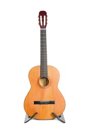Acoustic guitar on stand against white background