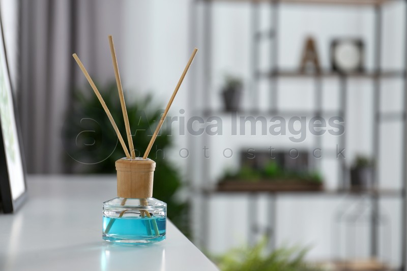 Reed air freshener on white shelf indoors. Space for text
