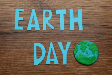 Words Earth Day and plasticine planet on wooden table, flat lay