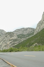 Picturesque landscape with mountains and asphalt highway outdoors. Road trip