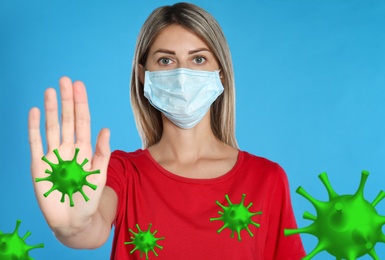 Stop Covid-19 outbreak. Woman wearing medical mask surrounded by virus on blue background