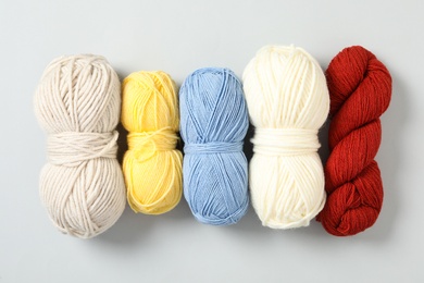 Soft colorful woolen yarns on white background, flat lay