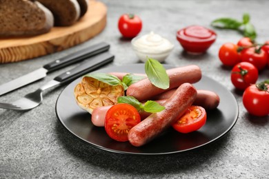 Delicious vegetarian sausages with basil and vegetables on grey table