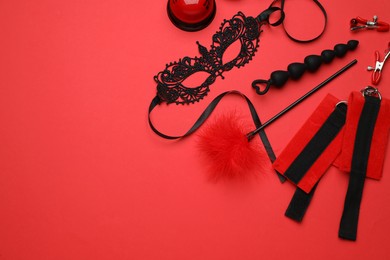 Photo of Sex toys and accessories on red background, flat lay. Space for text
