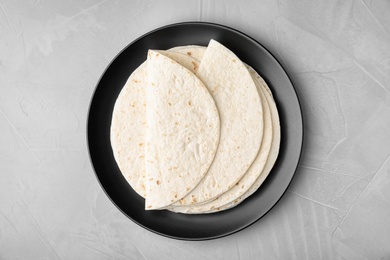 Plate with corn tortillas on grey background, top view. Unleavened bread