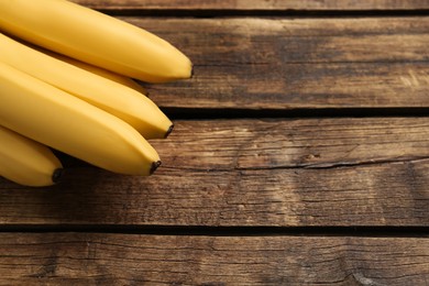 Ripe sweet yellow bananas on wooden table. Space for text
