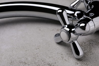 Double handle water tap on grey table, closeup